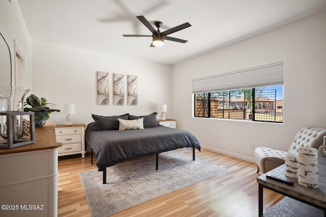 bedroom with light wood-style floors, ceiling fan, and baseboards