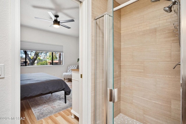 ensuite bathroom with ensuite bathroom, a shower stall, wood finished floors, and a ceiling fan