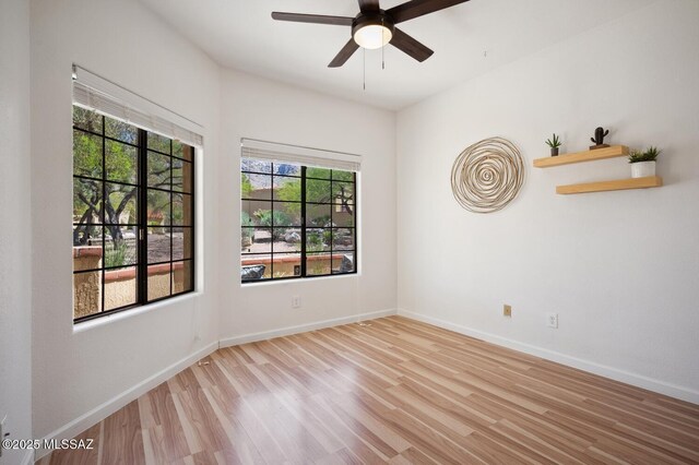 empty room with baseboards, a ceiling fan, and wood finished floors