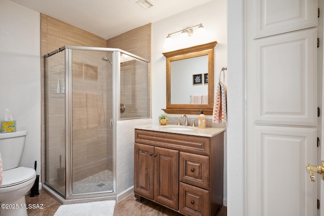 bathroom featuring toilet, a stall shower, vanity, and visible vents