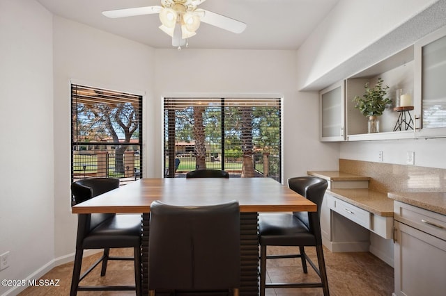 dining area with a wealth of natural light, baseboards, and ceiling fan