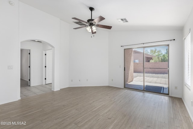 13140 E Mesquite Flat Spring Dr, Vail, AZ 85641 - spare room featuring arched walkways, light wood-style flooring, ceiling fan, and high vaulted ceiling