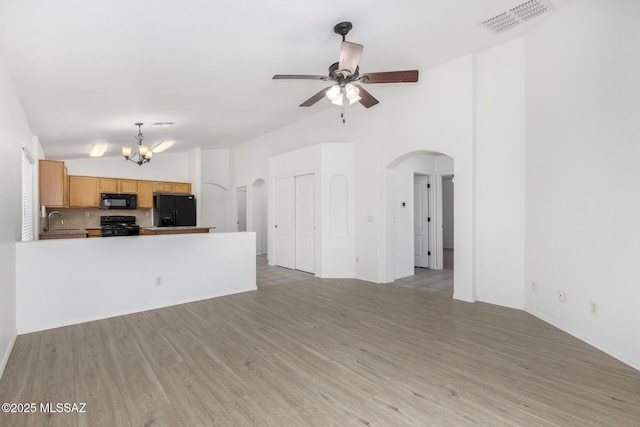 13140 E Mesquite Flat Spring Dr, Vail, AZ 85641 - unfurnished living room with a sink, arched walkways, a ceiling fan, light wood finished floors, and a chandelier