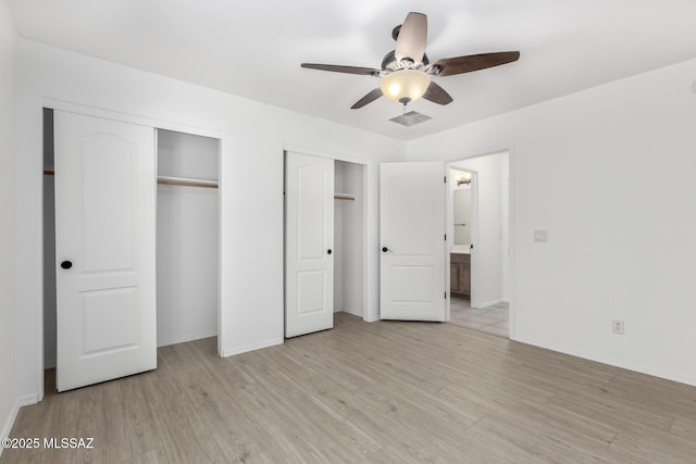 13140 E Mesquite Flat Spring Dr, Vail, AZ 85641 - unfurnished bedroom featuring multiple closets, light wood finished floors, baseboards, and connected bathroom