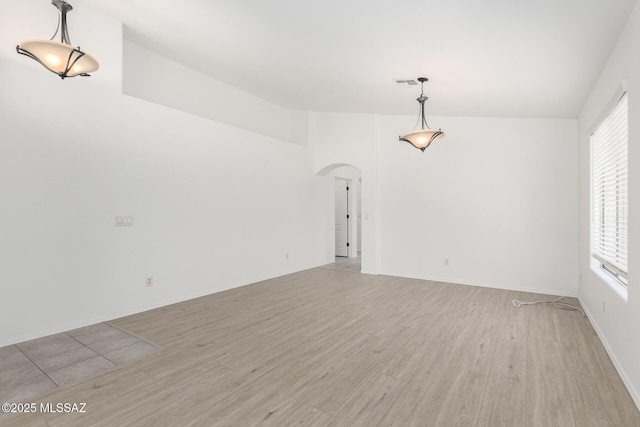 13140 E Mesquite Flat Spring Dr, Vail, AZ 85641 - empty room with arched walkways and light wood-style flooring