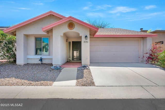 view of front facade featuring an attached garage, stucco siding, and driveway