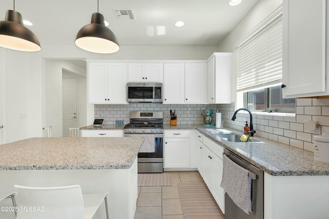 6548 E Via Arroyo Largo, Tucson, AZ 85756 - kitchen featuring appliances with stainless steel finishes, a sink, backsplash, white cabinetry, and light tile patterned floors