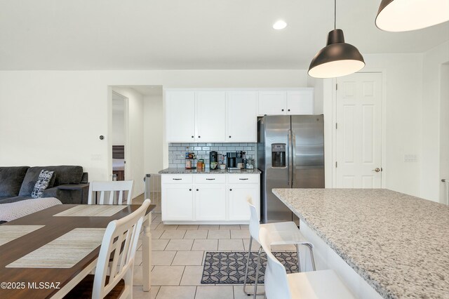 6548 E Via Arroyo Largo, Tucson, AZ 85756 - kitchen featuring stainless steel fridge, white cabinets, tasteful backsplash, light tile patterned floors, and light stone countertops