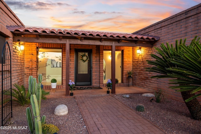 exterior entry at dusk featuring covered porch