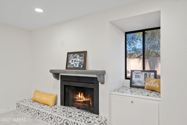 room details featuring recessed lighting, a warm lit fireplace, and baseboards