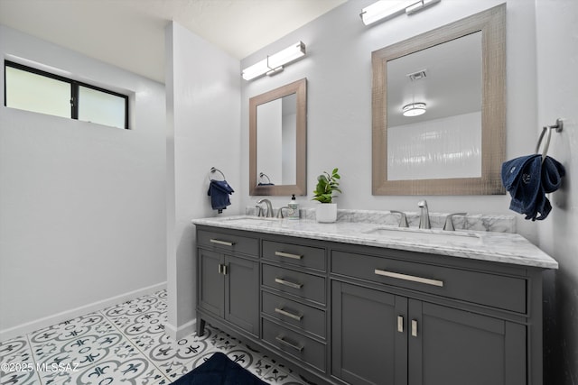 full bathroom with visible vents, a sink, baseboards, and double vanity