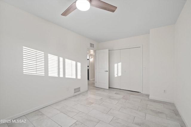 unfurnished room featuring baseboards, ceiling fan, and visible vents