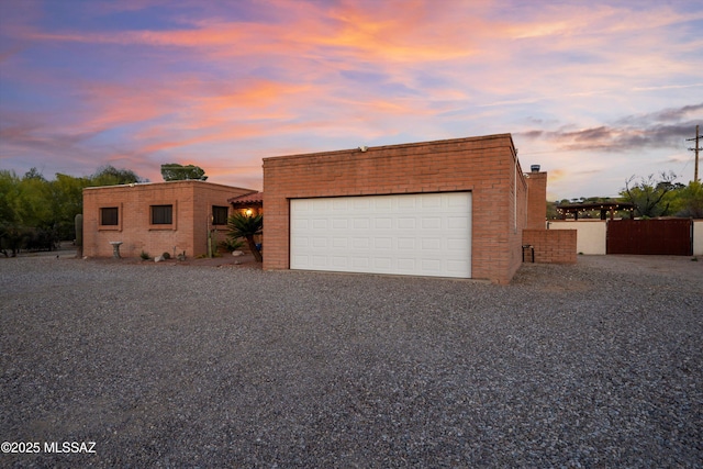 view of front of home with brick siding and gravel driveway