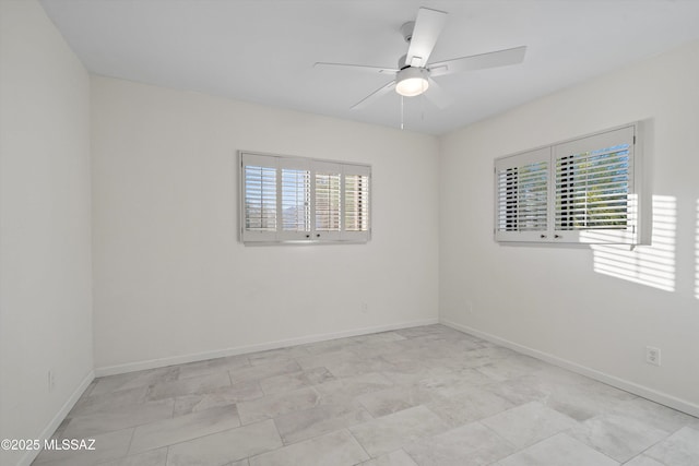 unfurnished room featuring ceiling fan and baseboards
