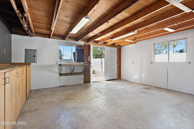 misc room with concrete floors and electric panel