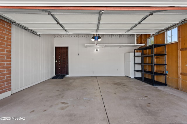 garage featuring freestanding refrigerator and a garage door opener