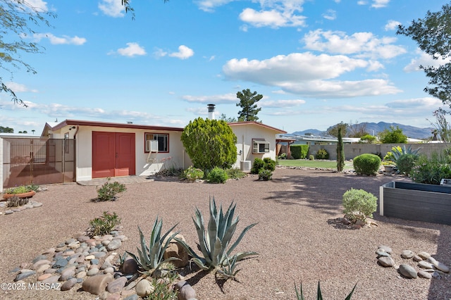 rear view of house featuring a mountain view and fence