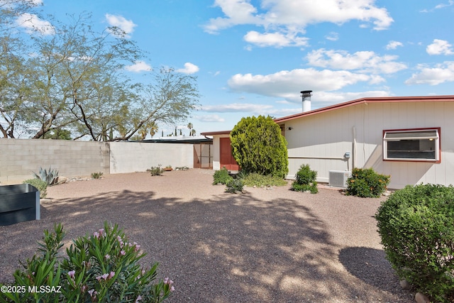 rear view of house featuring cooling unit and fence