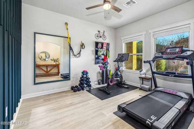 exercise area featuring visible vents, baseboards, a ceiling fan, and wood finished floors