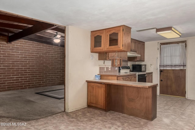 423 E Hadley St, Tucson, AZ 85705 - kitchen featuring a peninsula, visible vents, under cabinet range hood, brick wall, and range with electric cooktop