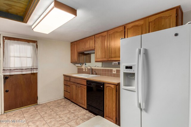 423 E Hadley St, Tucson, AZ 85705 - kitchen with light tile patterned floors, a sink, black dishwasher, white refrigerator with ice dispenser, and light countertops