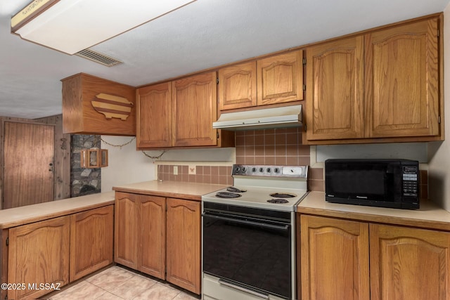 423 E Hadley St, Tucson, AZ 85705 - kitchen with range with electric stovetop, visible vents, under cabinet range hood, black microwave, and decorative backsplash