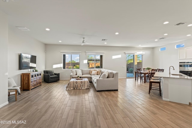 7797 S Indian Wheat Way, Tucson, AZ 85747 - living area with light wood-style floors, recessed lighting, baseboards, and ceiling fan