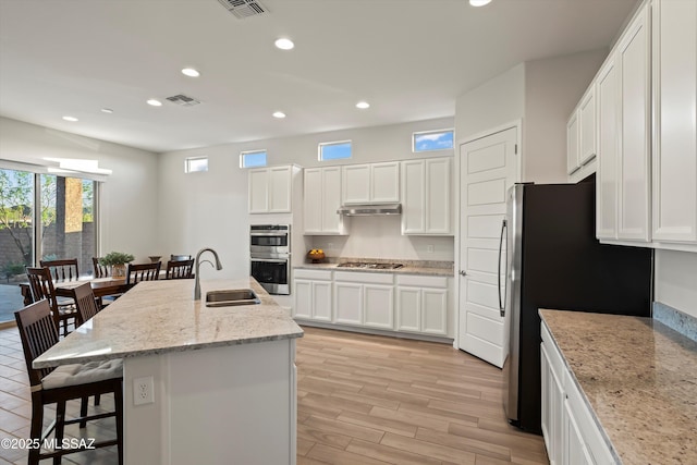 7797 S Indian Wheat Way, Tucson, AZ 85747 - kitchen featuring a sink, appliances with stainless steel finishes, a breakfast bar area, recessed lighting, and light wood finished floors