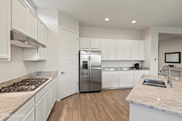 7797 S Indian Wheat Way, Tucson, AZ 85747 - kitchen with stainless steel appliances, a sink, light wood-style floors, white cabinetry, and recessed lighting