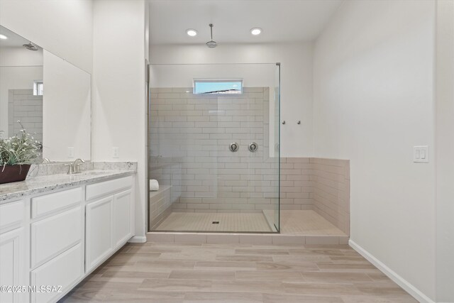 7797 S Indian Wheat Way, Tucson, AZ 85747 - bathroom featuring vanity, tiled shower, wood finished floors, recessed lighting, and baseboards