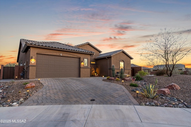 7797 S Indian Wheat Way, Tucson, AZ 85747 - mediterranean / spanish home with an attached garage, a tiled roof, decorative driveway, and stucco siding
