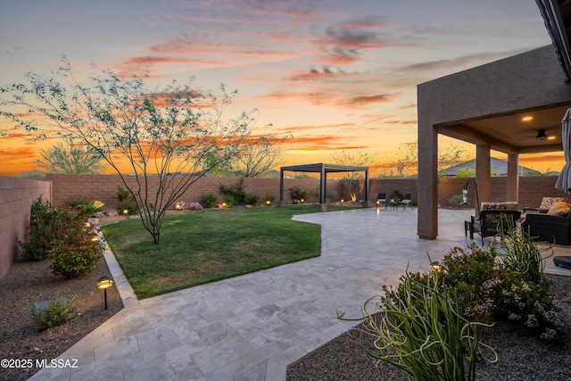 yard at dusk featuring a fenced backyard and a patio
