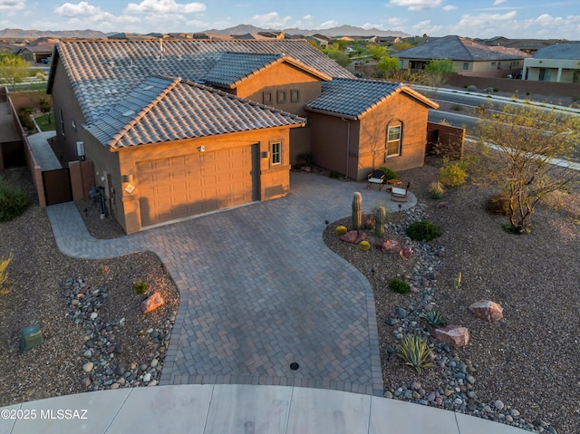 7797 S Indian Wheat Way, Tucson, AZ 85747 - view of front of property featuring a garage, a residential view, stucco siding, and a tiled roof