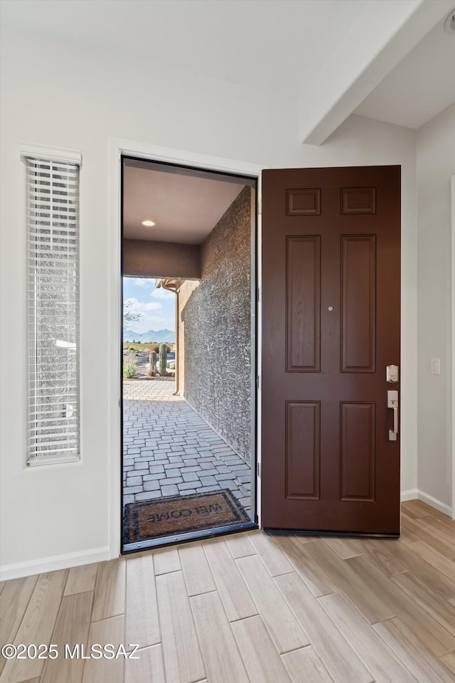 7797 S Indian Wheat Way, Tucson, AZ 85747 - foyer entrance featuring light wood-style floors, beam ceiling, and baseboards