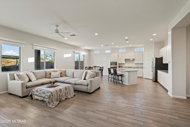 7797 S Indian Wheat Way, Tucson, AZ 85747 - living room featuring a ceiling fan, recessed lighting, light wood-style floors, and baseboards