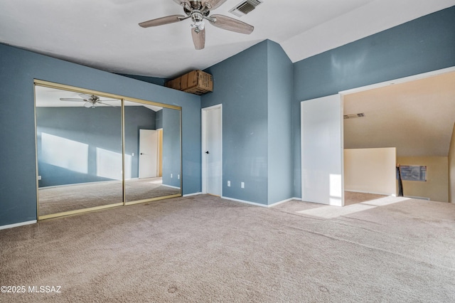 unfurnished bedroom featuring visible vents, carpet flooring, a closet, and lofted ceiling
