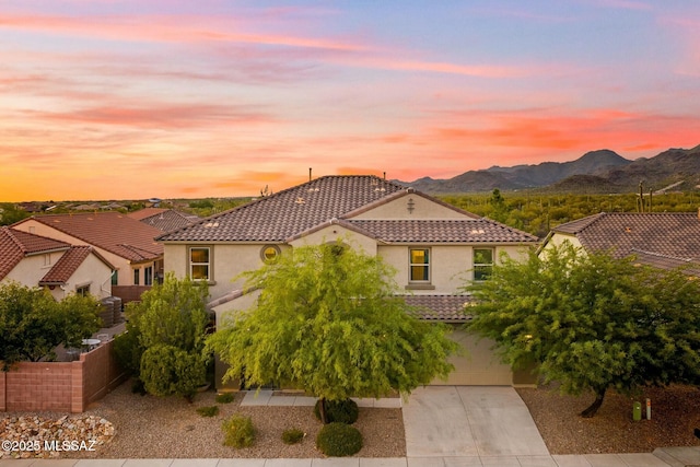 12487 N Wind Runner Pkwy, Marana, AZ 85658 - mediterranean / spanish-style house featuring stucco siding, a tiled roof, a mountain view, and concrete driveway