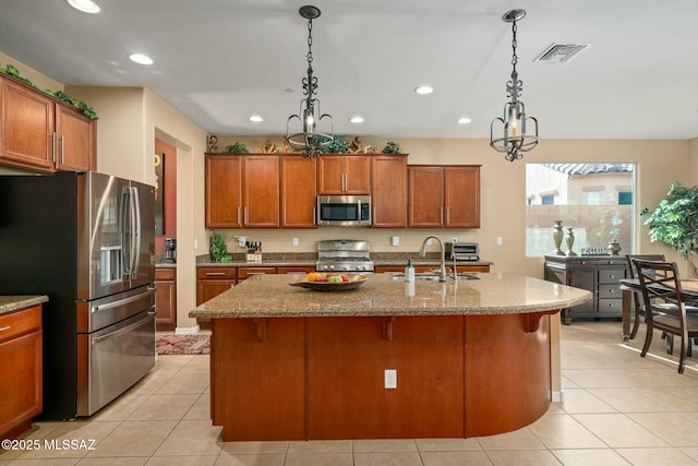 12487 N Wind Runner Pkwy, Marana, AZ 85658 - kitchen with appliances with stainless steel finishes, a sink, brown cabinetry, recessed lighting, and light stone countertops