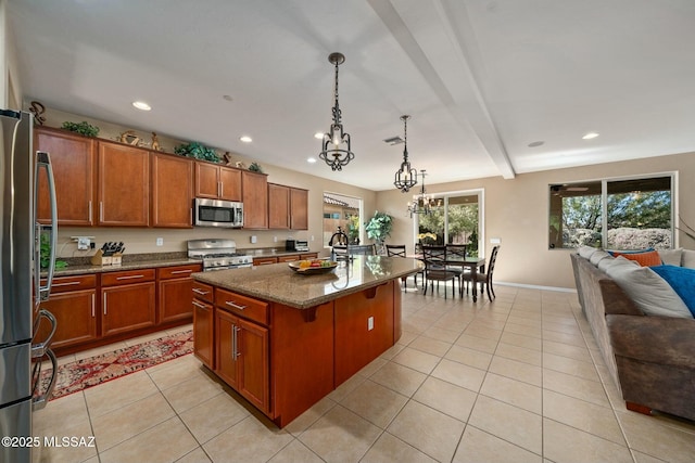 12487 N Wind Runner Pkwy, Marana, AZ 85658 - kitchen featuring appliances with stainless steel finishes, brown cabinetry, a chandelier, light tile patterned floors, and dark stone counters