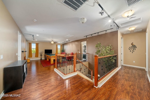12487 N Wind Runner Pkwy, Marana, AZ 85658 - hallway featuring wood finished floors, rail lighting, an upstairs landing, baseboards, and attic access