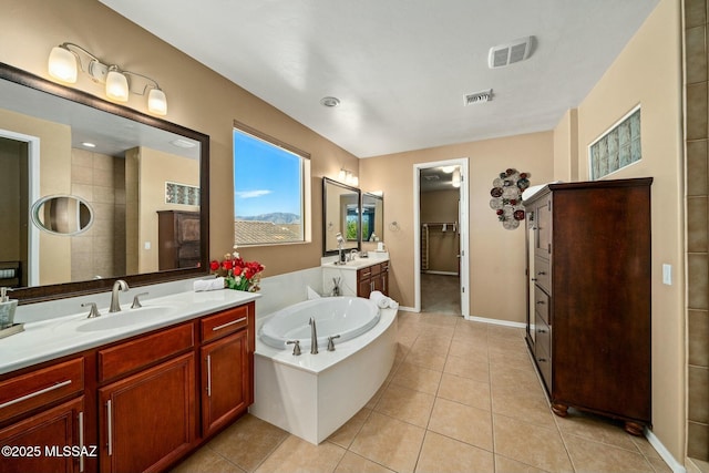 12487 N Wind Runner Pkwy, Marana, AZ 85658 - bathroom featuring tile patterned floors, two vanities, a bath, baseboards, and a spacious closet
