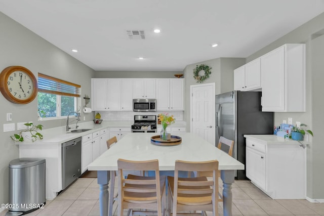 10391 E Malta St, Tucson, AZ 85747 - kitchen featuring white cabinets, appliances with stainless steel finishes, a sink, a center island, and light tile patterned floors