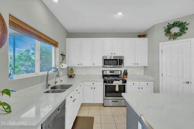 10391 E Malta St, Tucson, AZ 85747 - kitchen featuring appliances with stainless steel finishes, tasteful backsplash, a sink, light tile patterned floors, and white cabinetry