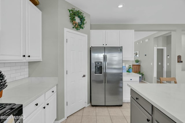 10391 E Malta St, Tucson, AZ 85747 - kitchen with backsplash, stainless steel refrigerator with ice dispenser, light countertops, light tile patterned floors, and white cabinets