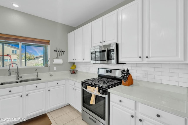 10391 E Malta St, Tucson, AZ 85747 - kitchen with decorative backsplash, a sink, light countertops, stainless steel appliances, and white cabinetry