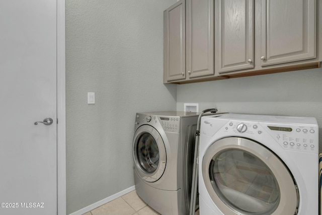 10391 E Malta St, Tucson, AZ 85747 - laundry room with cabinet space, baseboards, washing machine and dryer, and light tile patterned floors