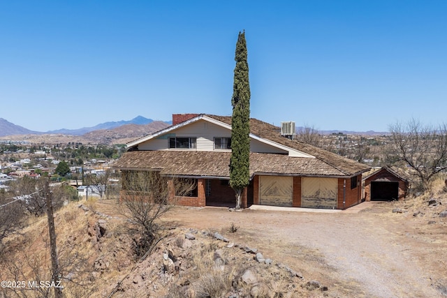view of front of property with central air condition unit, a mountain view, a garage, and driveway