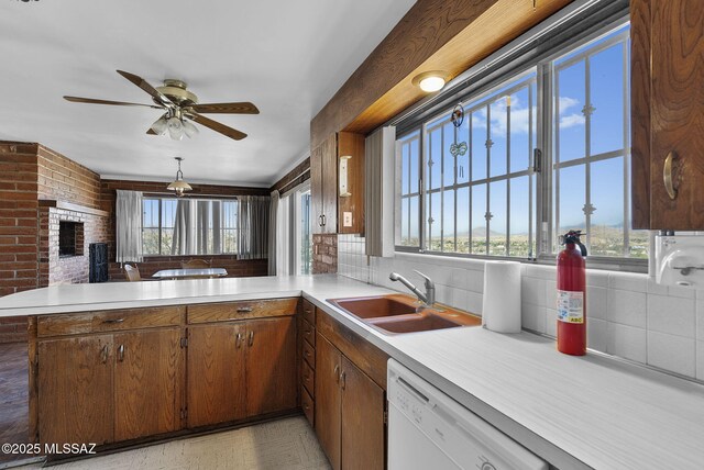 kitchen with light countertops, a healthy amount of sunlight, dishwasher, and a sink