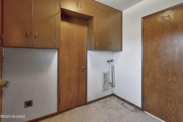 washroom with hookup for an electric dryer, baseboards, light floors, and cabinet space