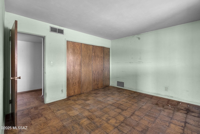 unfurnished bedroom with visible vents and a closet